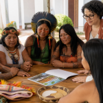 Representantes de uma universidade apresentam material de orientação e proteção para mulheres indígenas em um espaço institucional